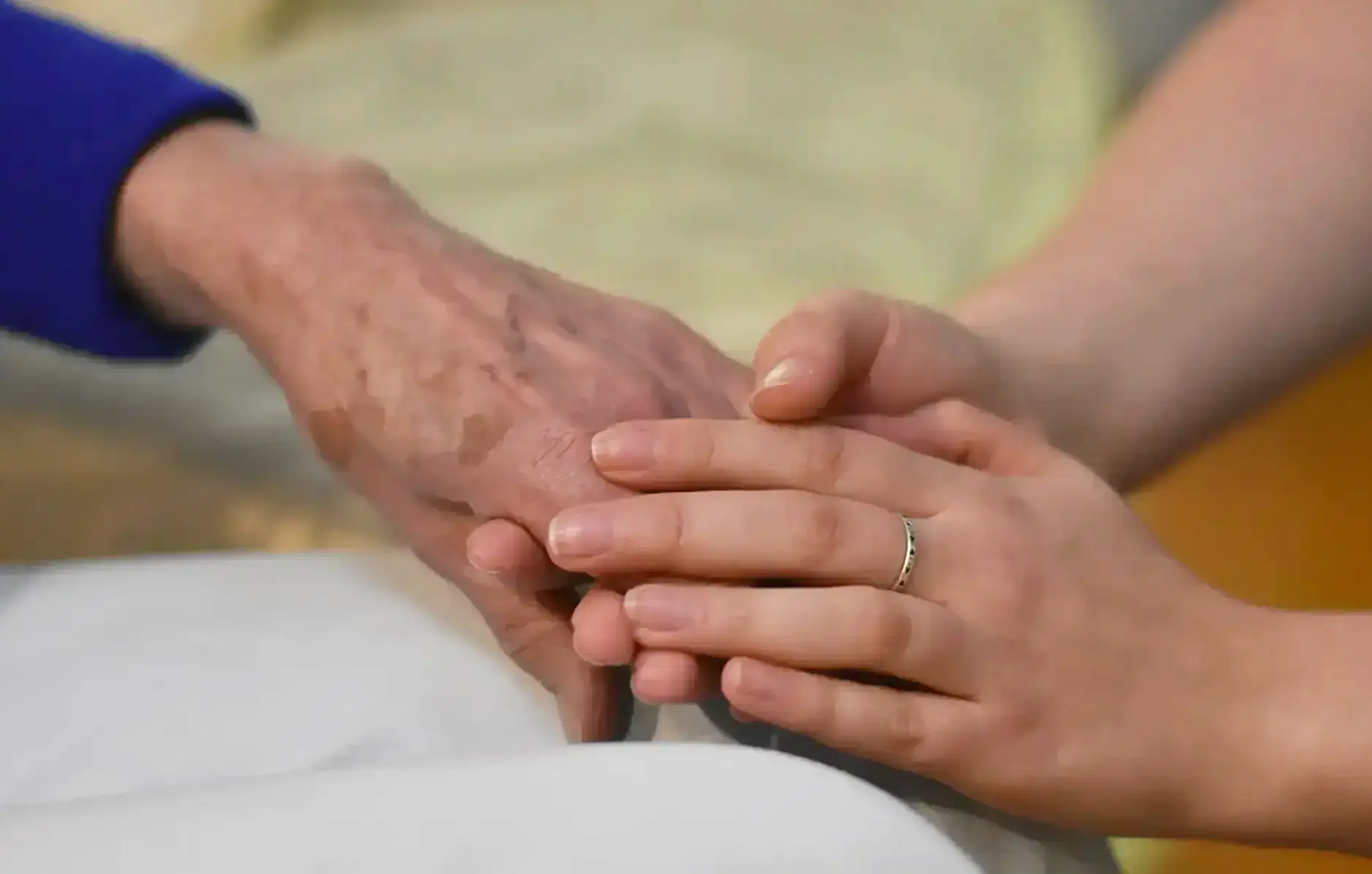 older-adult-caring-hand-fitness-trainer holding hands of older person